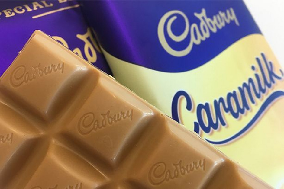 Cadbury i marka Caramilk; fot. mat.pras. Cadbury: żywy człowiek siedzi na bilboardzie i reklamuje batoniki